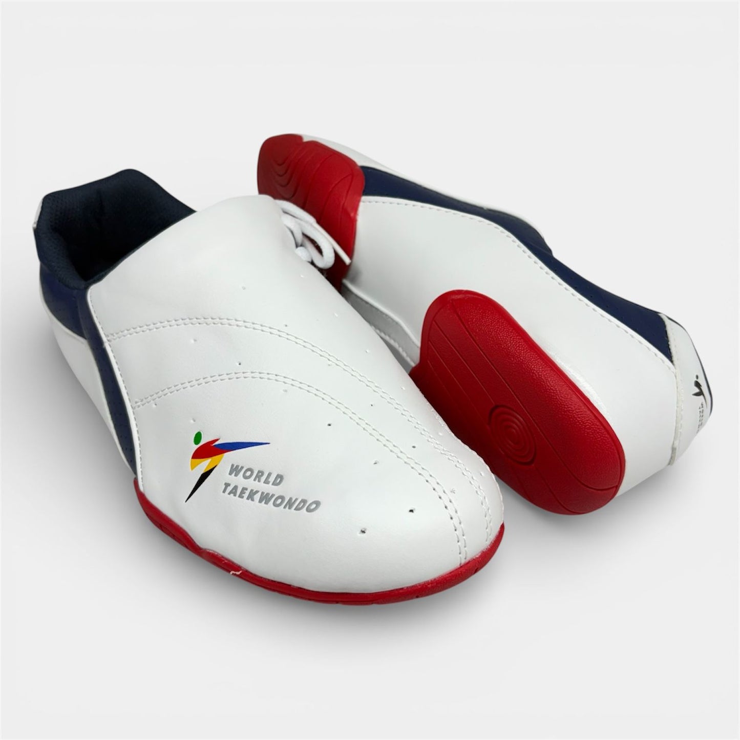 Pair of white taekwondo shoes with red and blue accents on a light gray background